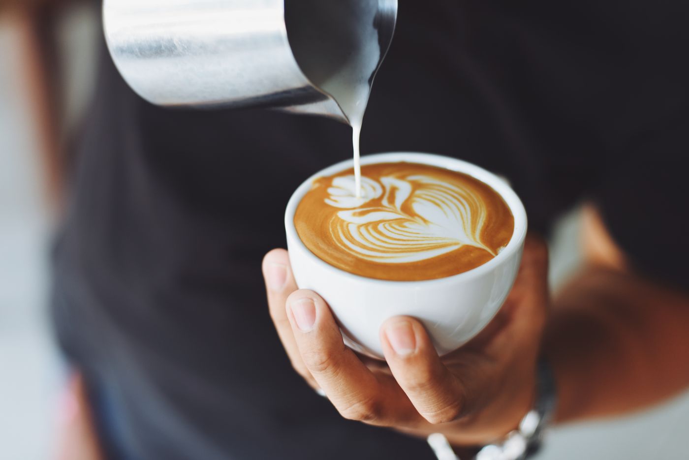 A barista pouring latte art used as an example Website subject